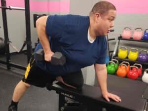 Glatter Fitness client performing a single-arm dumbbell row with excellent form and concentration.